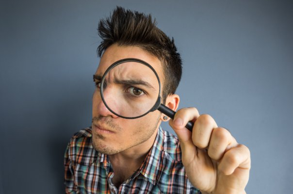 us search online background check service features man looking through magnifying glass